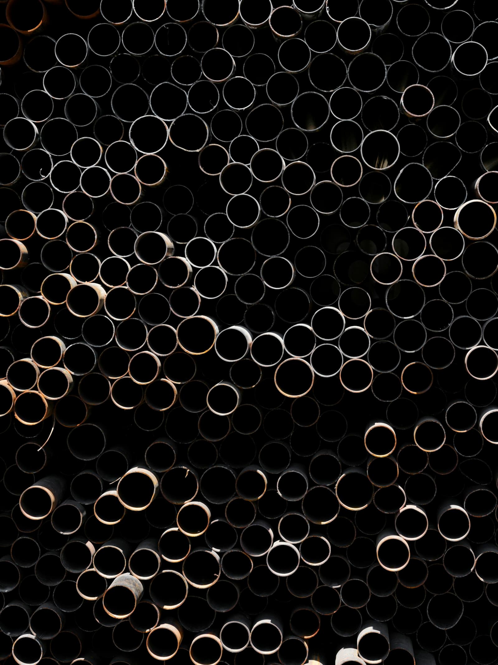 Dense stack of metal tubes in an industrial yard
