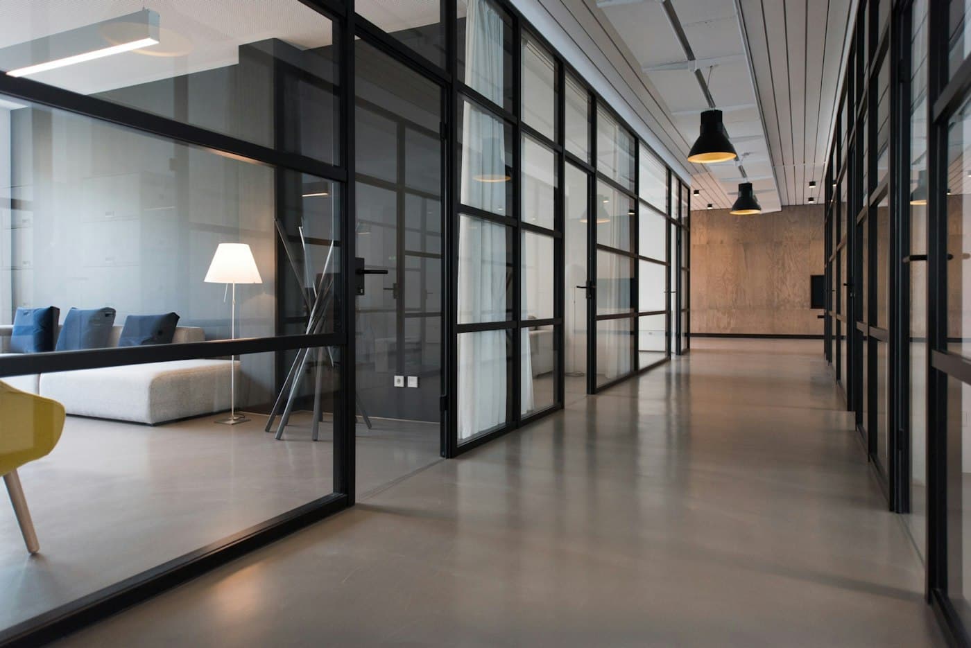 Glass office partitions running along a commercial corridor