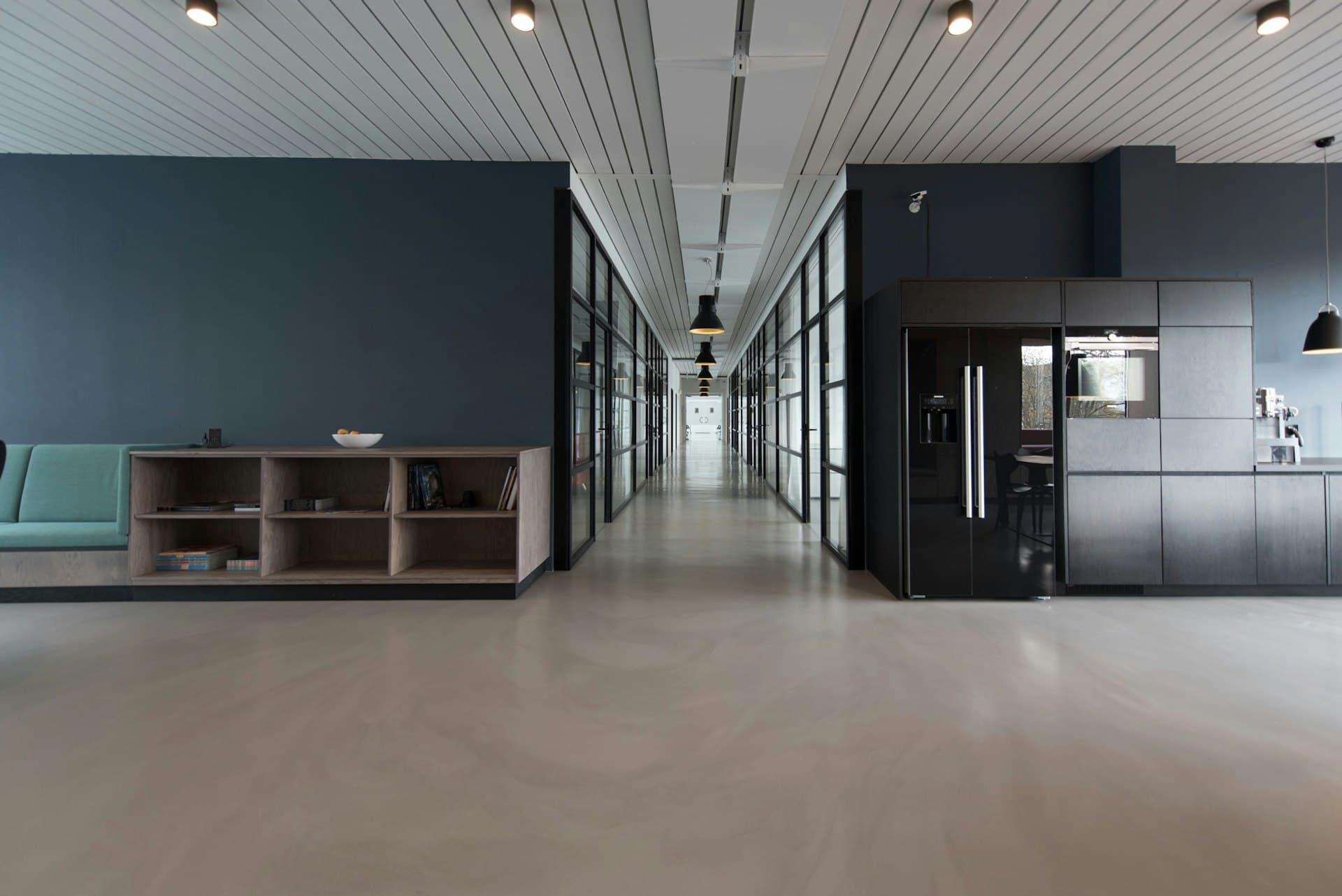 Commercial office interior with glass rooms and a wide circulation space